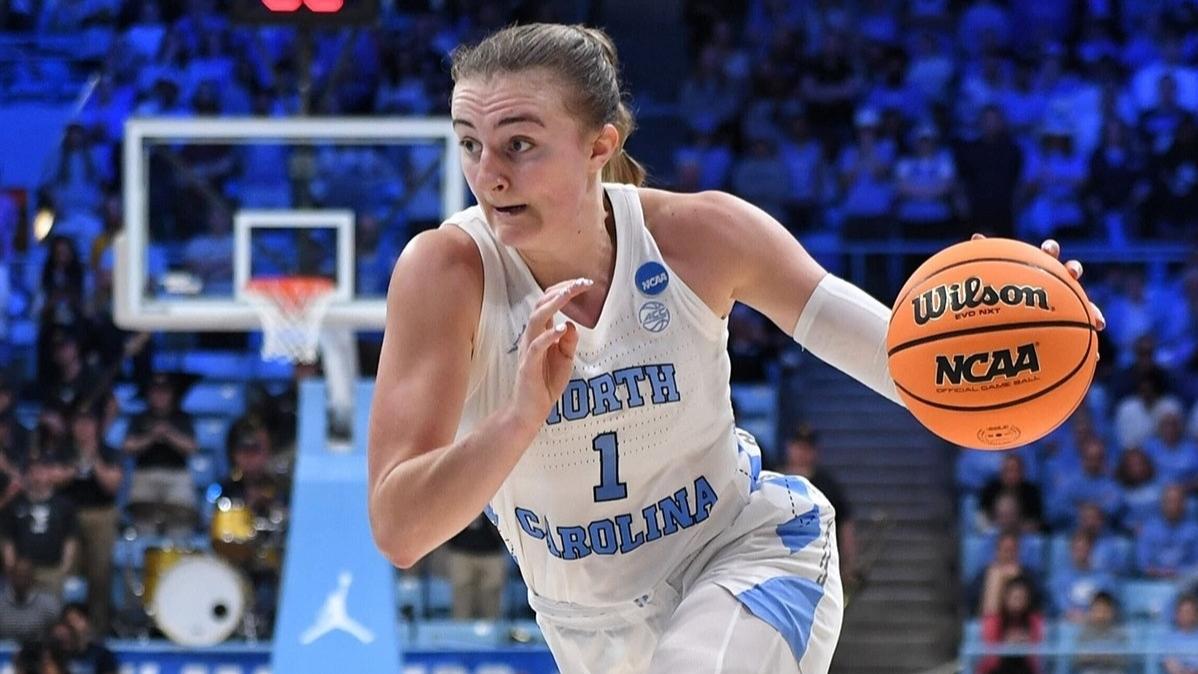 A women's basketball player dribbles down the court.